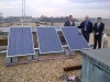 Officials atop the HCHB with solar panels
