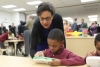 Commerce Secretary Penny Pritzker and a student at the Langdon Education Campus explore a LeapFrog handheld device, the 700,000th design patent awarded by the Unites States Patent and Trademark Office