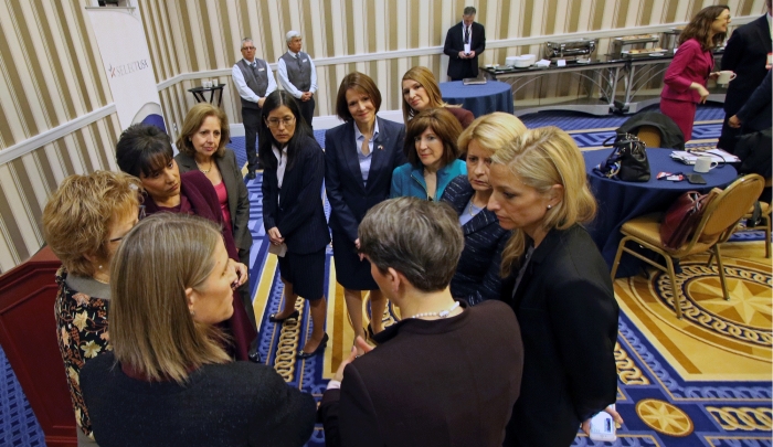 Secretary of Commerce Penny Pritzker huddles with 10 female U.S. Ambassadors at the 2015 SelectUSA Investment Summit. 