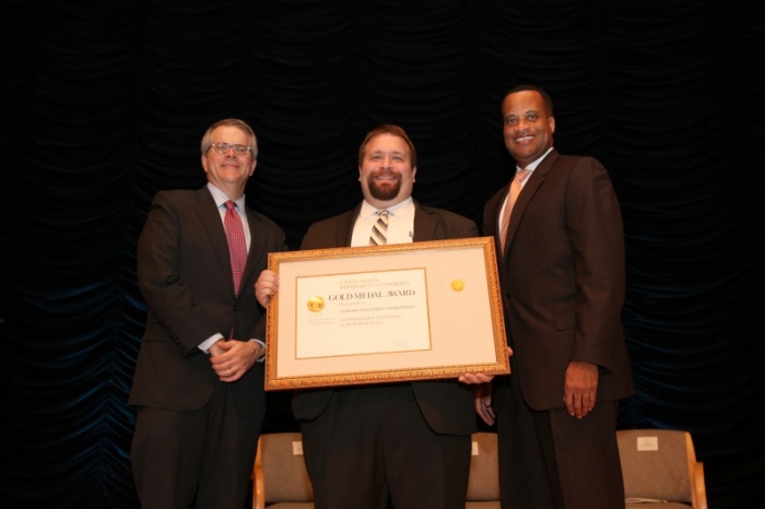 The EDA team holding their award aside Deputy Secretary Andrews.