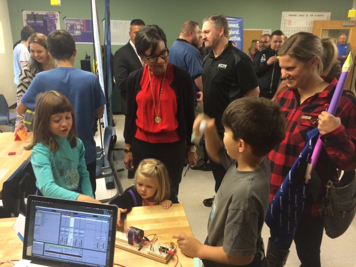 PDX Makers booth - Kids trying out a musical instrument that uses a small laser to generate notes