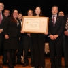 The ITA team holding their Gold Medal Award aside Deputy Secretary Andrews.