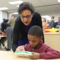 Commerce Secretary Penny Pritzker and a student at the Langdon Education Campus explore a LeapFrog handheld device, the 700,000th design patent awarded by the Unites States Patent and Trademark Office