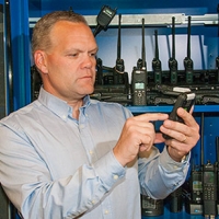 Dereck Orr with a variety of radios and cell phones used in NIST’s public safety communications research. A new NIST report outlines research needed on location-based services—applications such as GPS that can improve situational awareness for emergency r