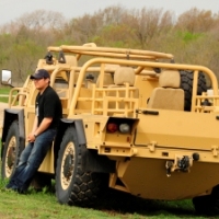 Thomas Hiromoto, Lockheed Martin engineer, leans against the Common Vehicle