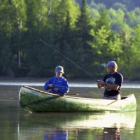 Photo of father and son fishing in canoe